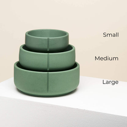 Three bowls in duck green in different sizes on top of each other.